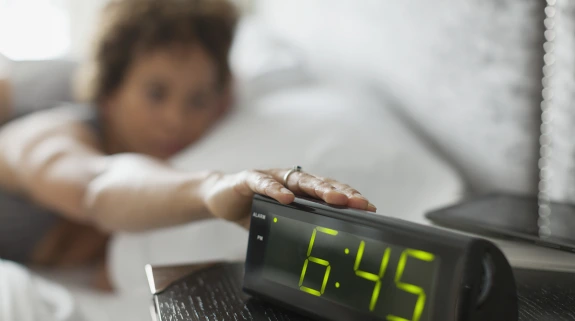 cozi hero image - woman reaching for alarm clock